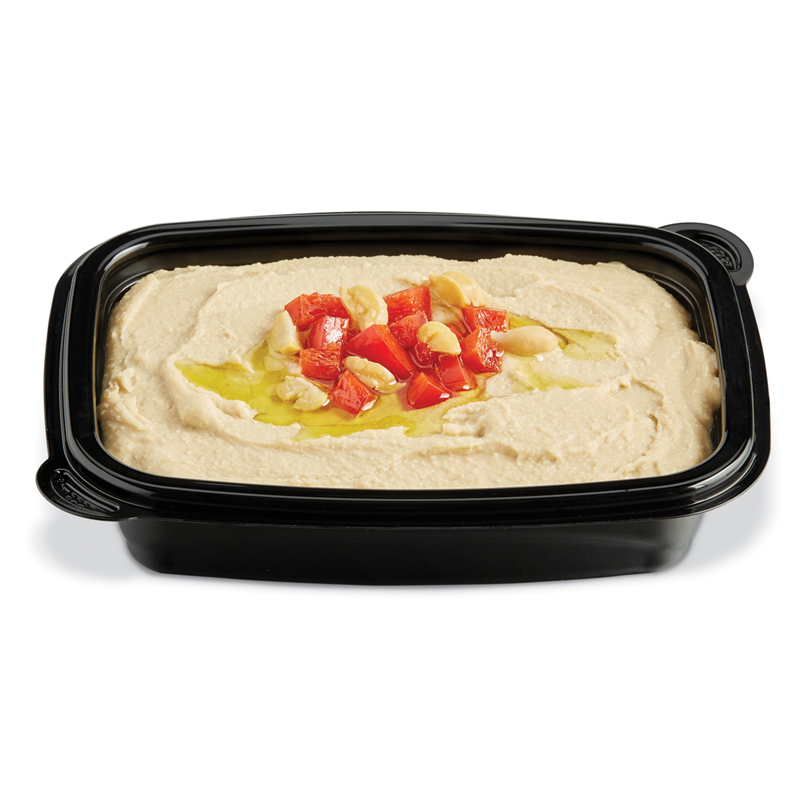 Hummus topped with olive oil and diced red peppers in a black tray