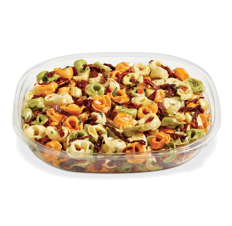 Bowl of tri-color tortellini pasta salad with sun-dried tomatoes and herbs