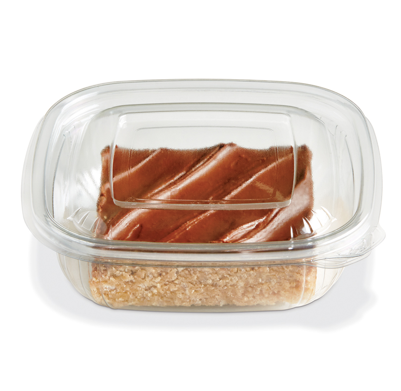 Glazed brown food layered over a crumbly base in a clear plastic container