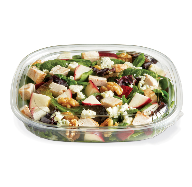 Salad with grilled chicken, mixed greens, apples, walnuts, and blue cheese in a clear container