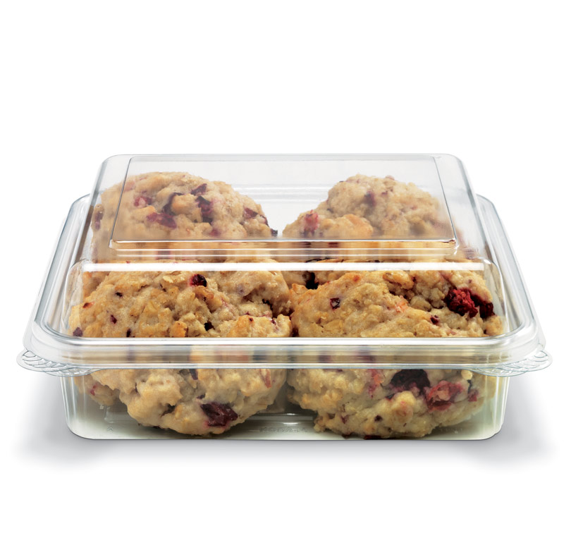 Clear plastic container filled with chunky cookies containing red fruit pieces and nuts