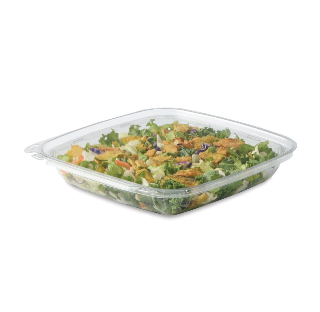 Mixed green salad with crispy toppings in a clear plastic container