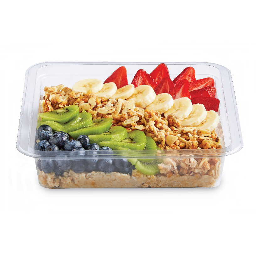 Clear container of granola topped with sliced strawberries, bananas, kiwi, and blueberries