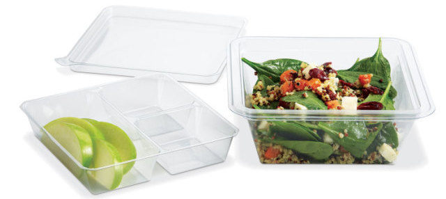 Clear plastic food containers holding a salad and lime slices