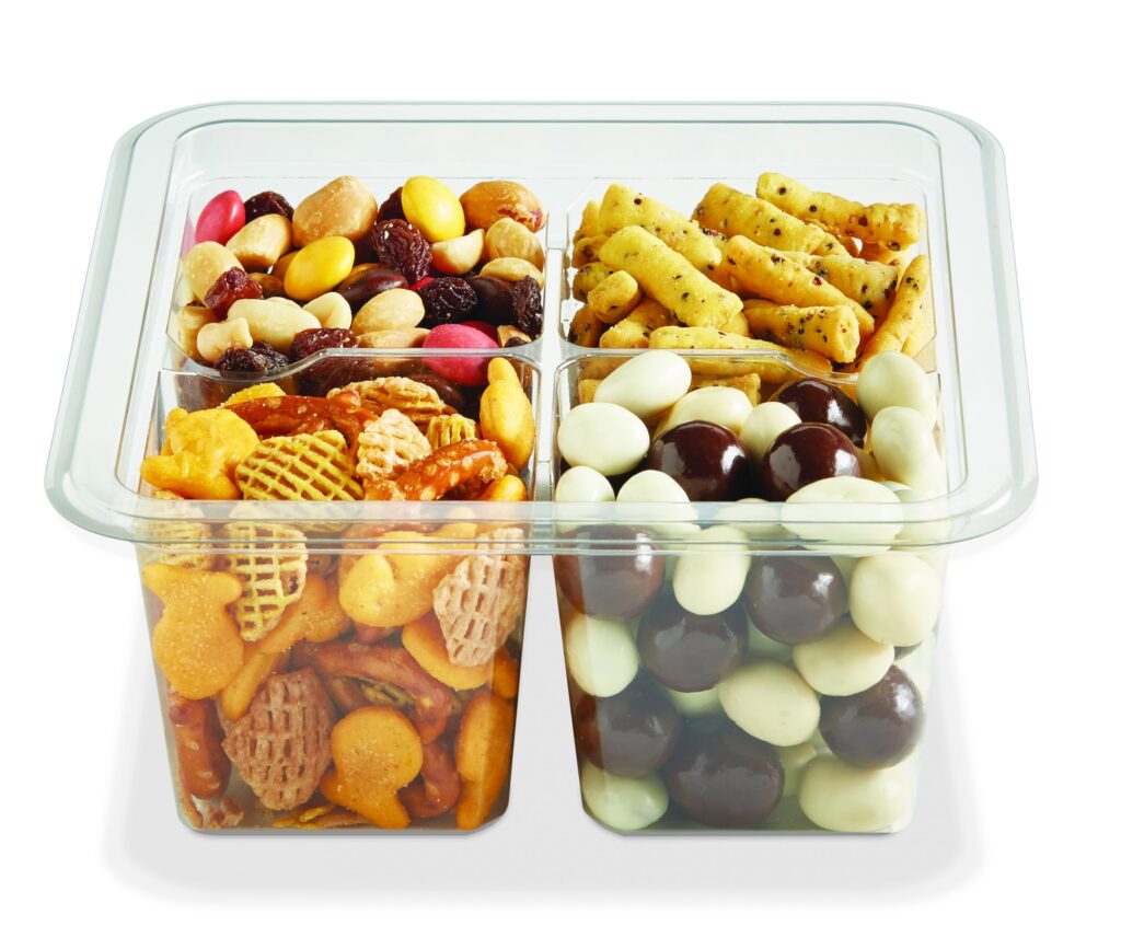 Compartmentalized snack tray filled with nuts, dried fruit, crackers, pretzels, and candy-coated chocolates