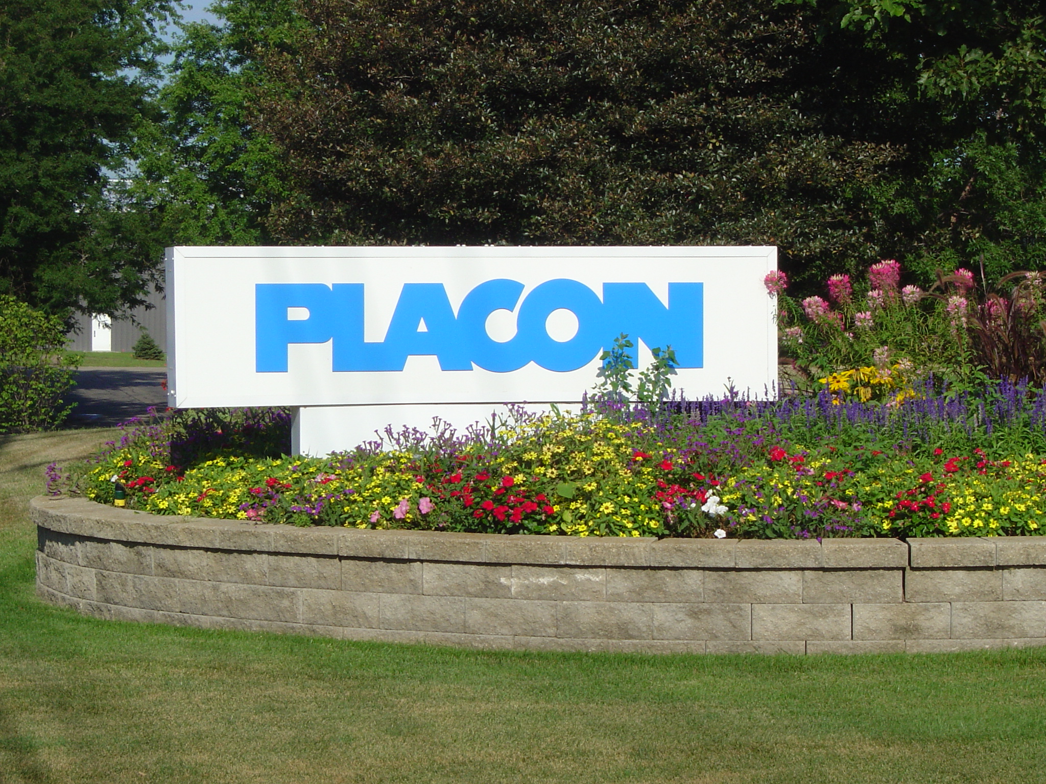 PACON sign surrounded by a colorful flower bed and trees