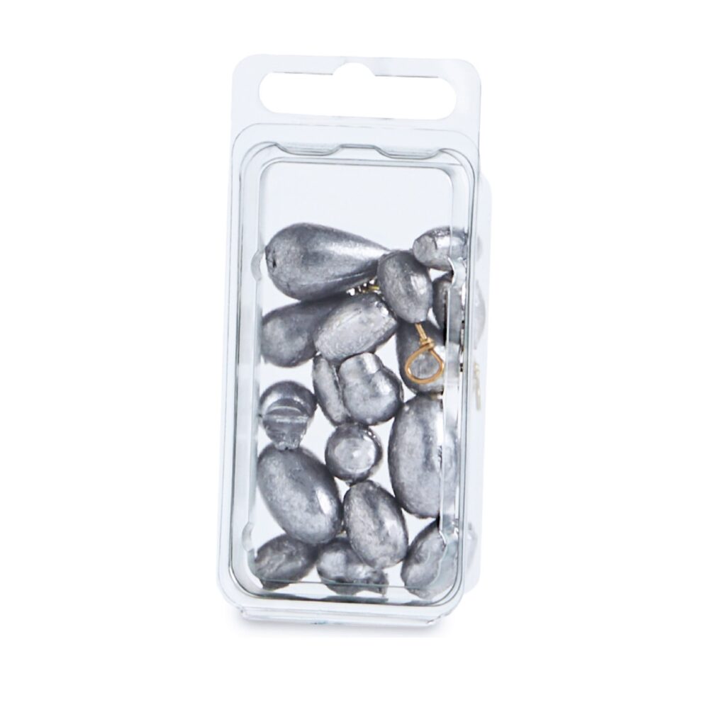 Clear rectangular case containing smooth dark gray stones and a small gold-colored ring