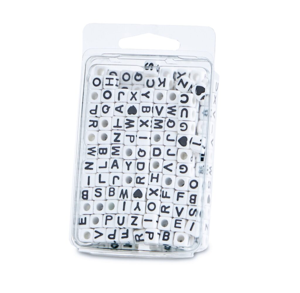 Package of white letter tiles in a clear plastic case