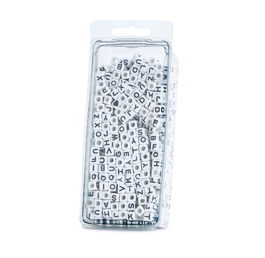 Clear package filled with white alphabet beads