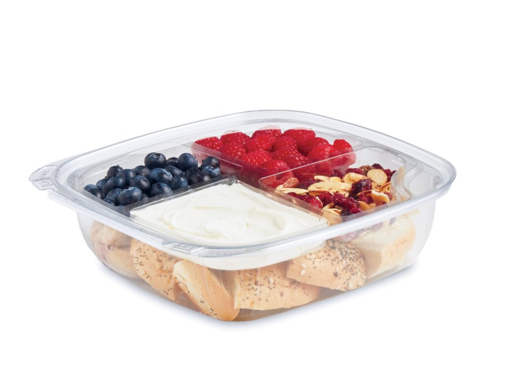 Clear container of blueberries, raspberries, yogurt, dried fruit, and crackers