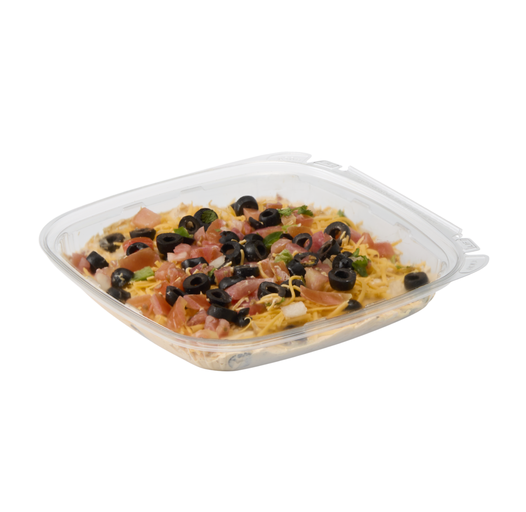 Taco salad with shredded cheese, diced tomatoes, black olives, lettuce, and herbs in a covered dish