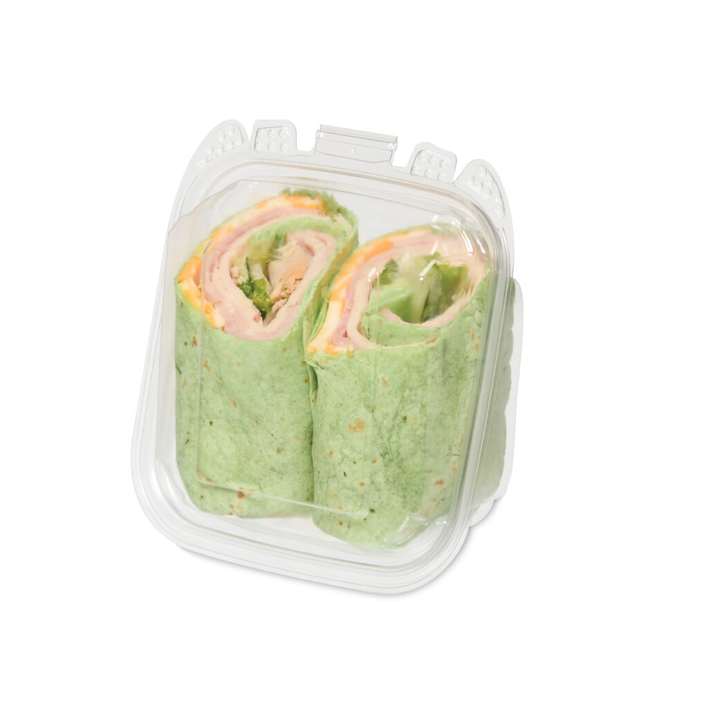 Container of sliced spinach wraps filled with ham, cheese, and lettuce