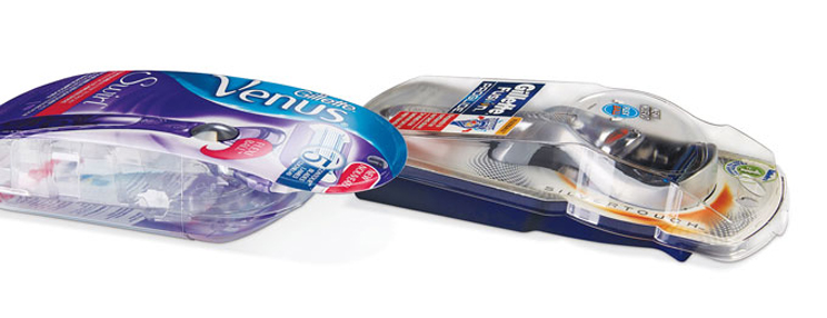 Two packaged Gillette razors, including a purple-and-blue Venus razor and a gray-and-blue men’s razor