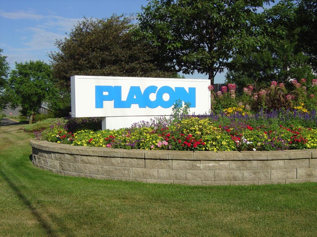 Landscaped entrance sign reading “PLACON” surrounded by colorful flowers