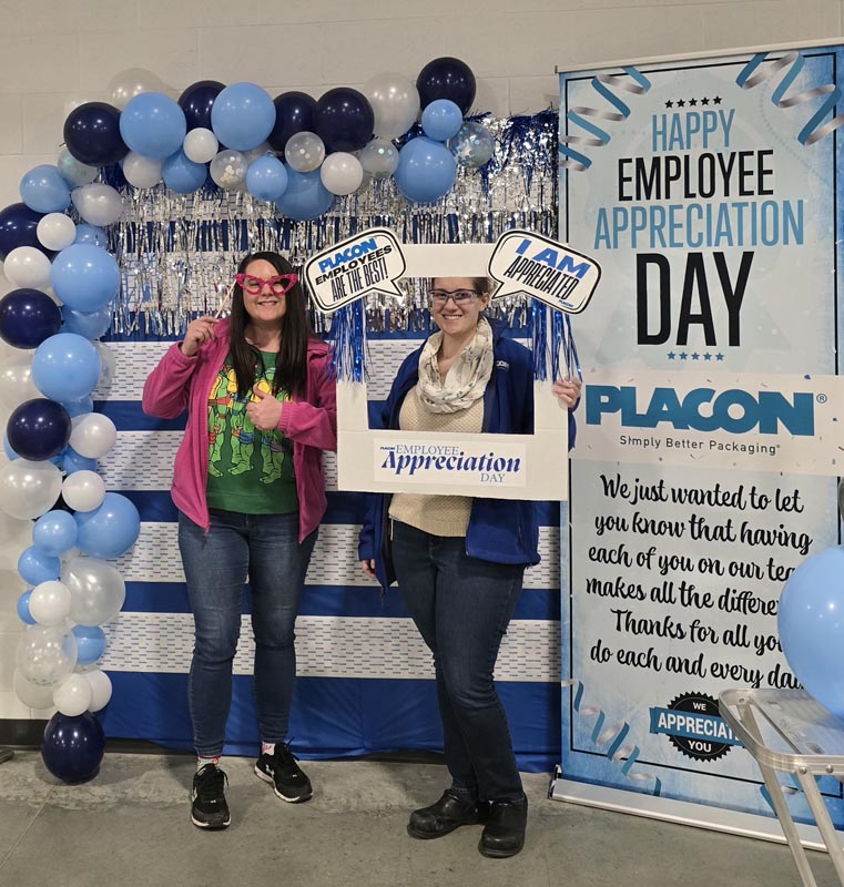 Careers 2 Two employees pose at a decorated Employee Appreciation Day display with balloons and appreciation signs