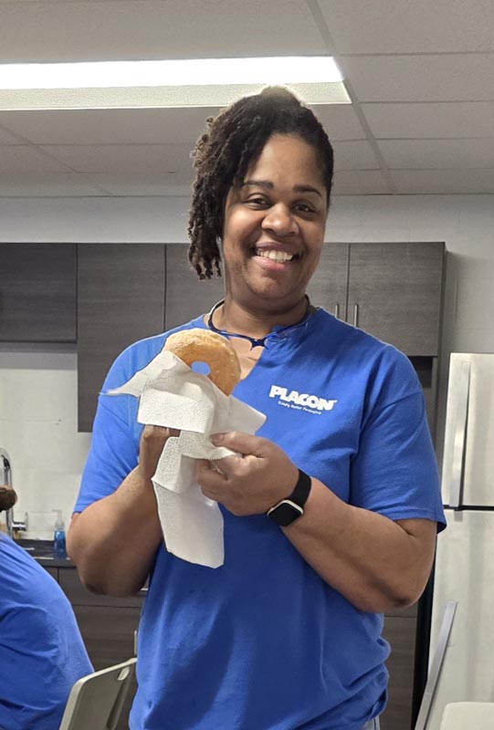 Careers 35 Smiling woman in a blue shirt holds a small brown-and-white object wrapped in paper towels