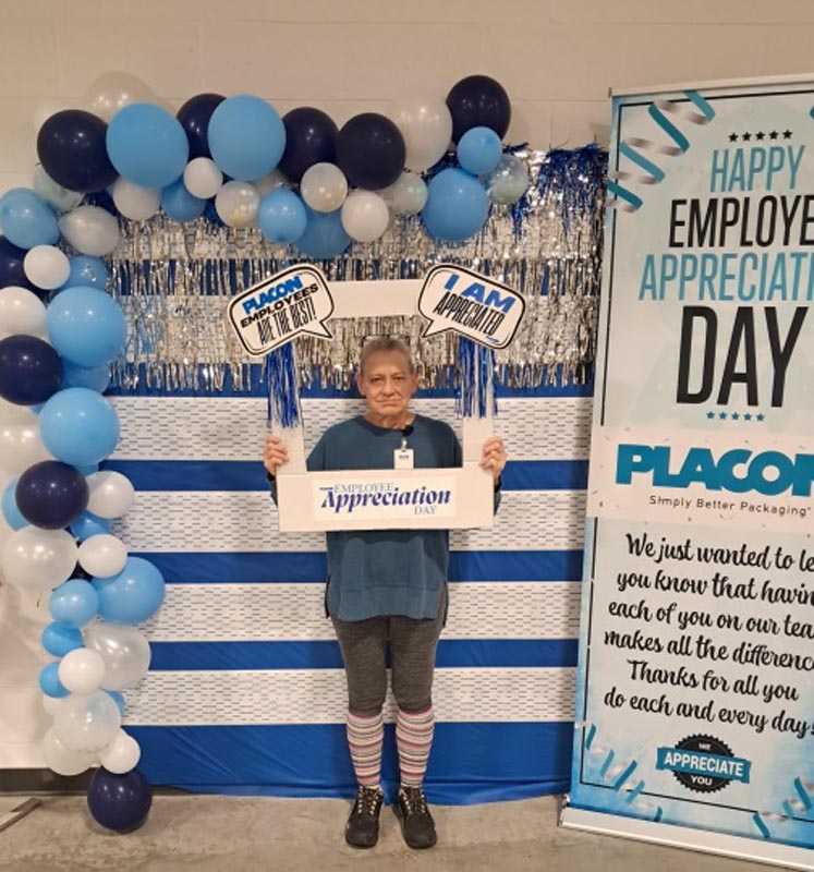 Careers 31 Employee holding an “Appreciation Day” sign in front of blue, white, and silver balloons and a workplace appreciation display
