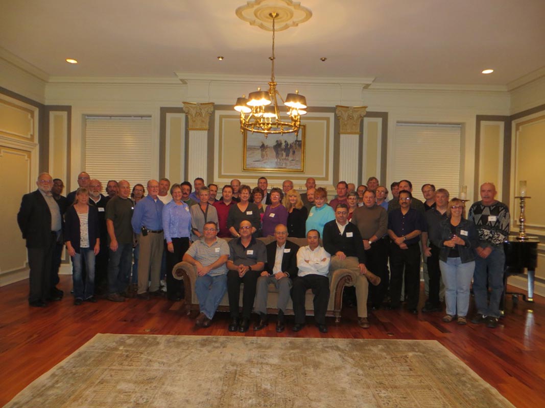 Careers 20 Large group posing for a photo in an ornate room, with several people seated in front