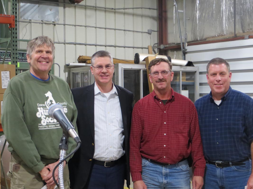 Careers 13 Four men stand in a workshop behind a microphone