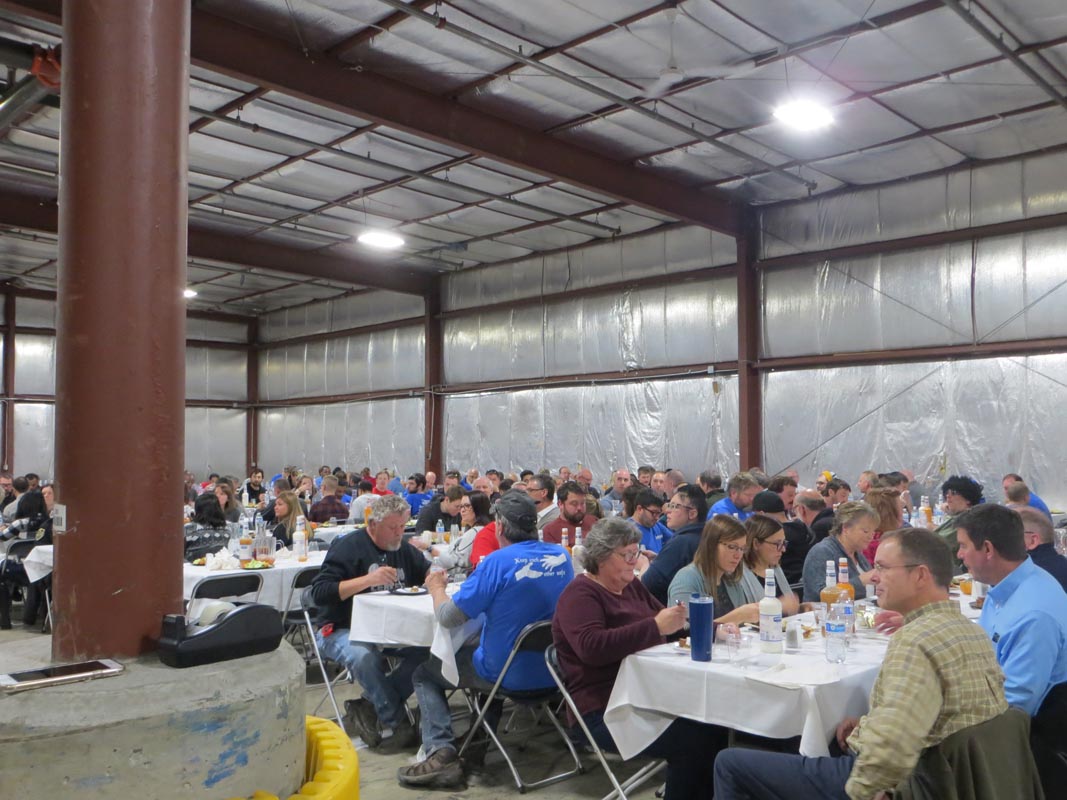 Careers 12 People seated at tables eating a meal in a large industrial hall