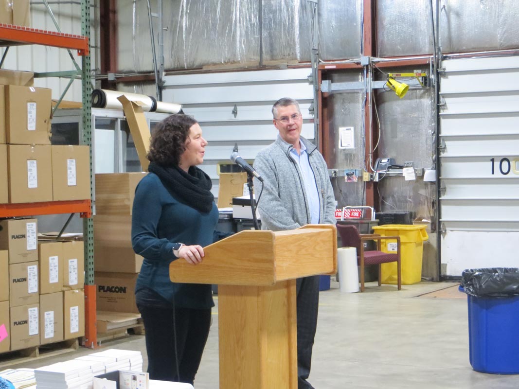 Careers 11 Two people stand at a podium with a microphone in a warehouse