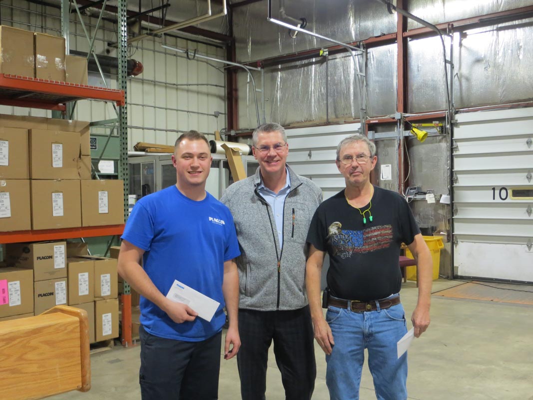 Careers 9 Three men stand together in a warehouse, with two holding papers