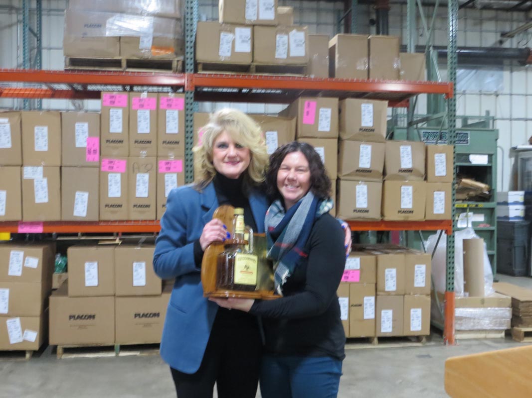 Careers 6 Two women pose in a warehouse while holding a bottle of liquor