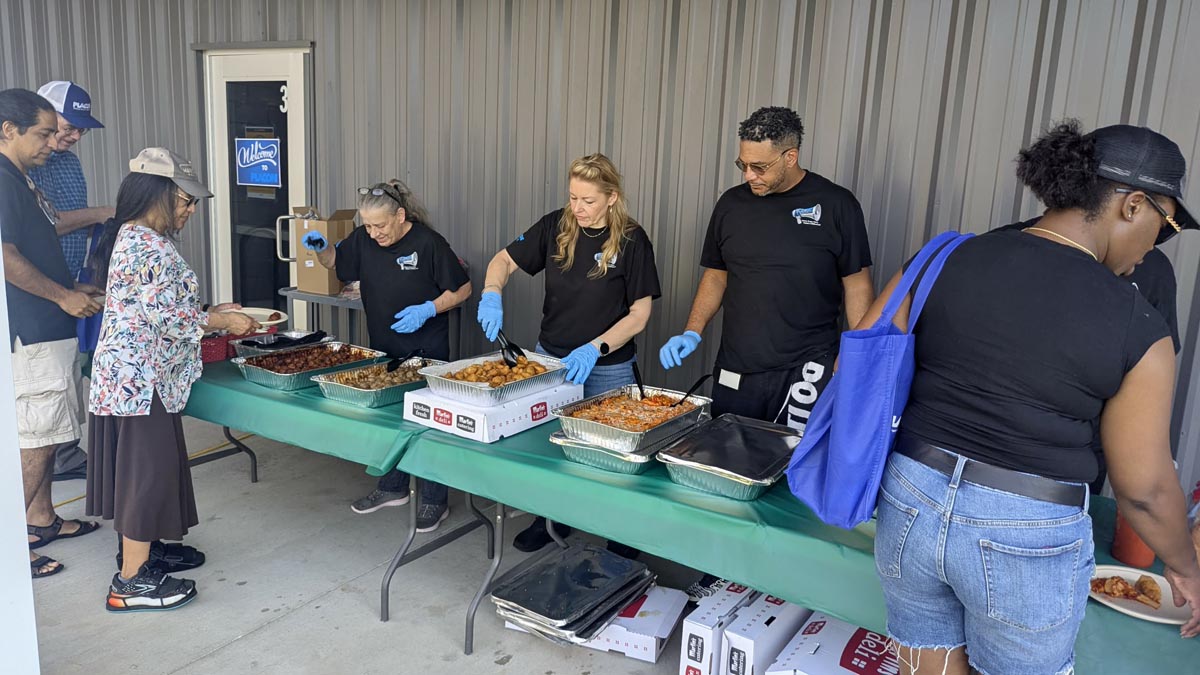Careers 25 Volunteers serve food to people at a community meal table