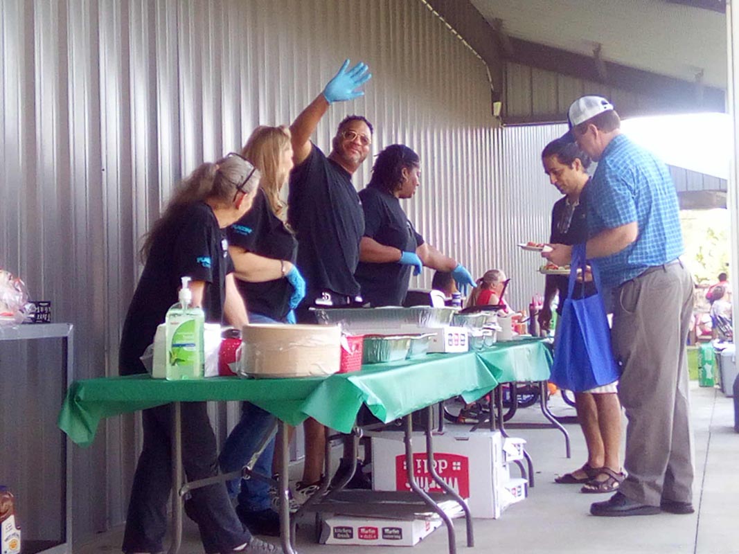 Careers 23 Volunteers serve food at a buffet table while people line up