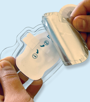 Hands peeling the backing from a medical adhesive patch